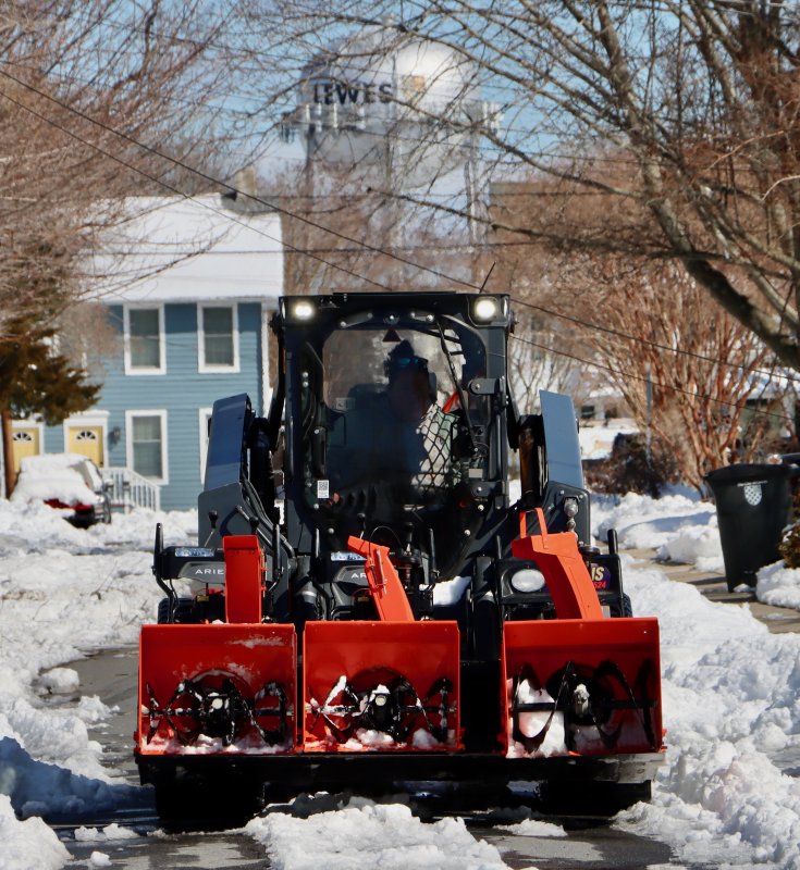 A plow makes its way down Railroad Avenue, with the iconic Lewes water tank in the background.
